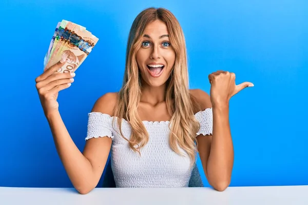 Krásná Blondýnka Mladá Žena Drží Kanadské Dolary Ukazující Palec Nahoru — Stock fotografie