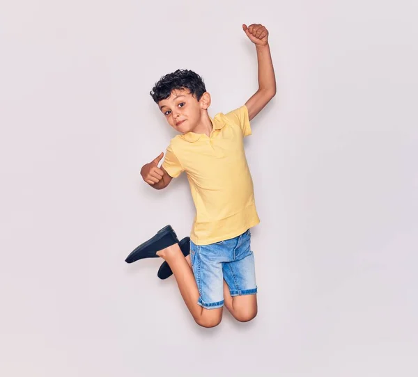 Adorable Niño Con Ropa Casual Saltando Sobre Fondo Blanco Aislado — Foto de Stock