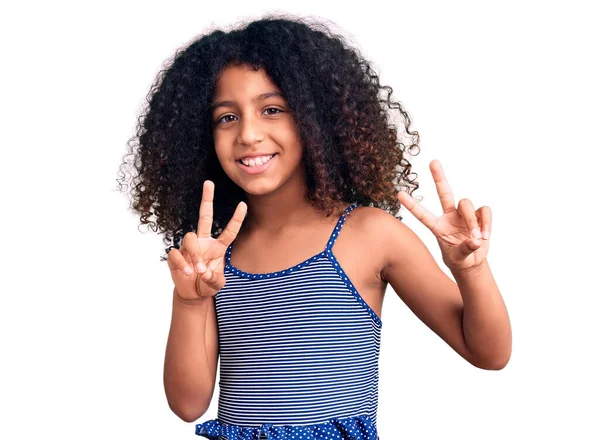勝利のサインを行う指を示すカメラに笑みを浮かべて水着を着て巻き毛を持つアフリカ系アメリカ人の子供 — ストック写真