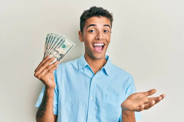 Joven Hombre Afroamericano Guapo Sosteniendo Billetes Dólares Celebrando Logro Con —  Fotos de Stock