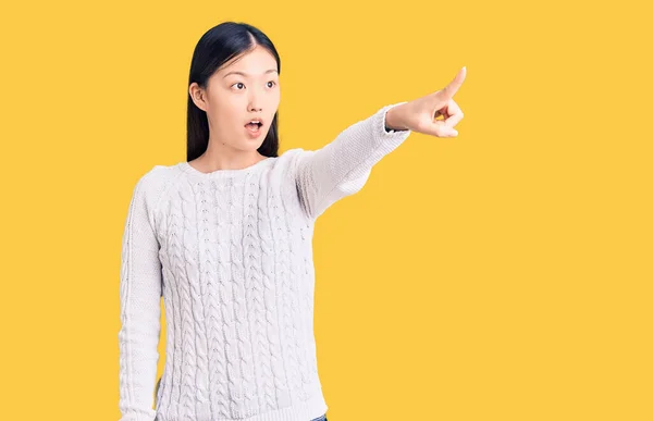 年轻美丽的中国女人穿着休闲装 手指指向前方 张开嘴惊讶的表情 前面有什么东西 — 图库照片