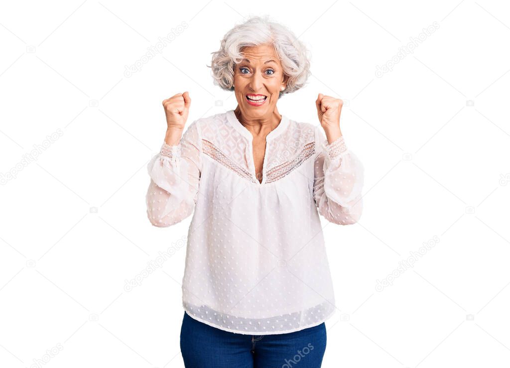 Senior grey-haired woman wearing casual clothes celebrating surprised and amazed for success with arms raised and open eyes. winner concept. 
