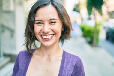 Genç ve güzel bir kız gülümsüyor. Mutlu bir şekilde yürüyor.