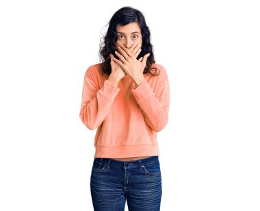 Gündelik kıyafetler giyen genç ve güzel İspanyol kadın yanlışlıkla elleri ile ağzını kapatırken şok oldu. gizli kavram. 