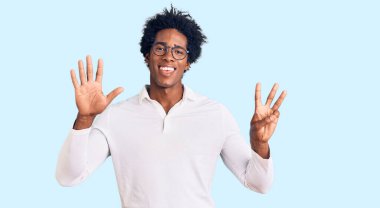 Yakışıklı Afro saçlı, sıradan kıyafetler giyen ve gözlüklü, 8 numaralı parmaklarıyla işaret eden, kendinden emin ve mutlu bir Amerikalı.. 