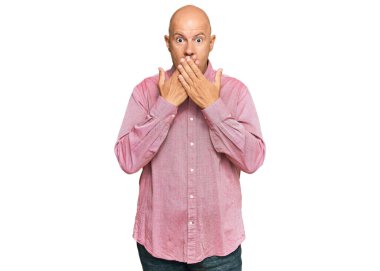 Sıradan kıyafetler giyen orta yaşlı kel bir adam yanlışlıkla elleri ile ağzını kapatırken şok oldu. gizli kavram. 