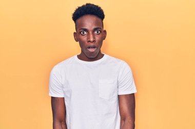 Genç Afro-Amerikan adam günlük giysiler giyiyor. Şaşırmış ve şaşırmış bir ifadeyle, korku ve heyecanlı bir yüzle.. 