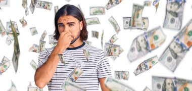 Sıradan kıyafetler giyen genç yakışıklı bir adam pis ve iğrenç bir koku alıyor, dayanılmaz bir koku, nefesini burnunda tutuyor. Kötü kokuyor.