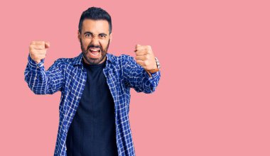 Öfkeli ve kızgın giyinmiş genç İspanyol adam öfkeyle bağırırken kızgın ve öfkeli yumruklar sallıyor. öfke ve agresif konsept. 