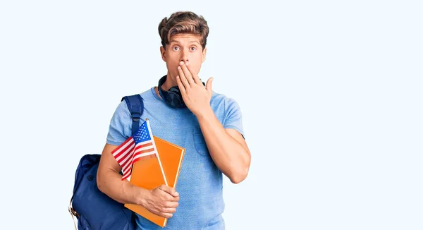 Młody Przystojny Mężczyzna Studenckim Plecaku Słuchawkach Książką Amerykańską Flagą Zakrywającą — Zdjęcie stockowe