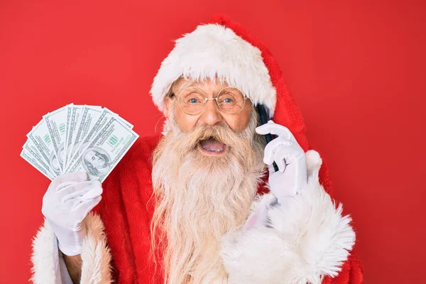 Gammal Äldre Man Bär Tomte Kostym Hålla Dollar Och Smartphone — Stockfoto