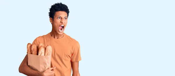 Jovem Afro Americano Segurando Saco Papel Com Pão Irritado Louco — Fotografia de Stock