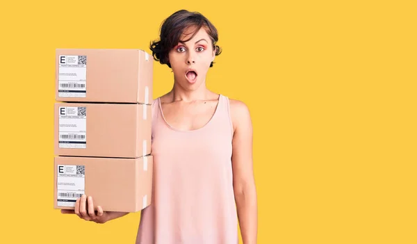 Beautiful Young Woman Short Hair Holding Delivery Packages Scared Amazed — Stock Photo, Image