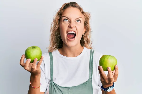 Όμορφη Καυκάσια Γυναίκα Κρατά Πράσινα Μήλα Θυμωμένα Και Τρελά Ουρλιάζοντας — Φωτογραφία Αρχείου