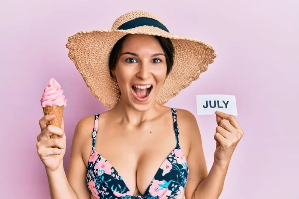 若いですブルネット女性とともに短い髪保持アイスクリームと7月紙祝うクレイジーと驚きのために成功とともにオープン目叫び興奮 — ストック写真