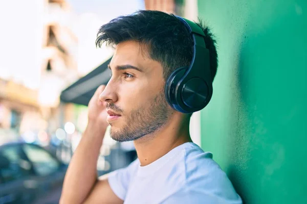 Νεαρός Λατίνος Άνδρας Χαλαρή Έκφραση Χρησιμοποιώντας Ακουστικά Στην Πόλη — Φωτογραφία Αρχείου