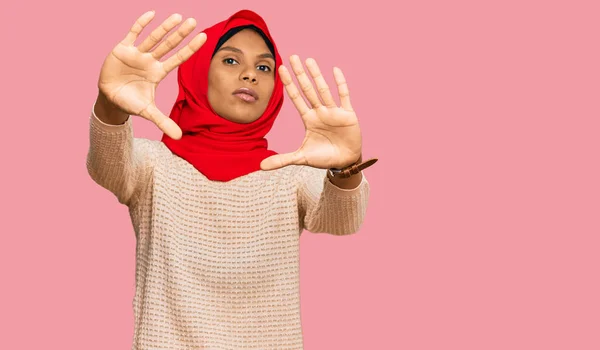 身穿传统伊斯兰头巾的年轻非洲裔美国妇女用手心和手指头做框架 镜头透视 — 图库照片