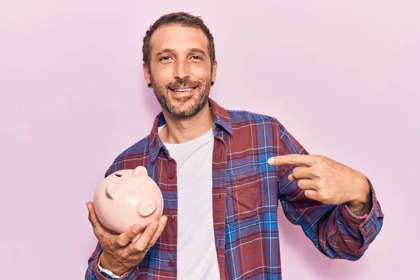 Young Handsome Man Holding Piggy Bank Pointing Finger One Self — Stock Photo, Image