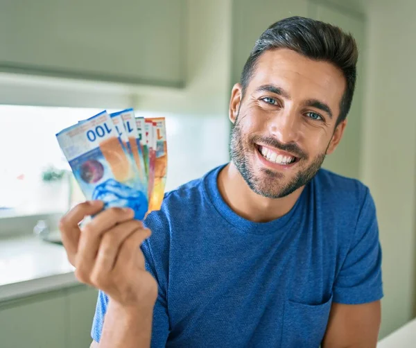 Young Handsome Man Smiling Happy Holding Swiss Franc Banknotes Home — ストック写真