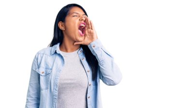 Uzun saçlı, sıradan bir kot ceket giyen İspanyol bir kadın el ve ağızla bağırıp çağırıyordu. iletişim konsepti. 