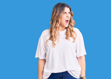 Kafkasyalı genç bir kadın günlük kıyafetler giyiyor kızgın ve kızgın bağırıyor sinirli ve öfkeli, öfkeyle bağırıyor. öfke ve agresif konsept. 