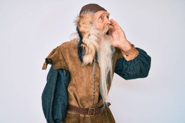 Gri saçlı, uzun sakallı, Viking kostümü giyen yaşlı bir adam el ele verip bağırıyor ve bağırıyor. iletişim konsepti. 