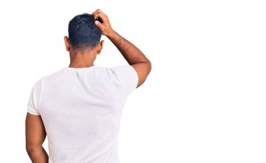 Gündelik giysiler giyen genç latin adam elleri kafasında şüpheyi düşünüyor. 