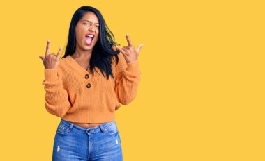 Uzun saçlı, sıradan bir kazak giyen, çılgın bir ifadeyle bağıran, elleri havada rock sembolü yapan İspanyol bir kadın. Müzik yıldızı. ağır kavram. 