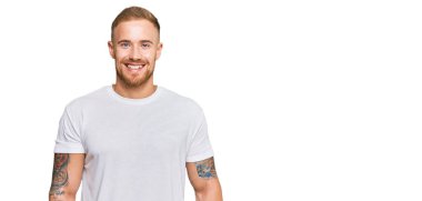 Genç İrlandalı bir adam, mutlu ve havalı bir gülümsemesi olan sıradan kıyafetler giyiyor. şanslı kişi. 