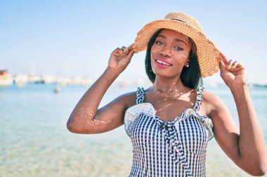 Genç Afrikalı Amerikalı kadın tatilde. Kumsalda mutlu bir şekilde yürüyordu.