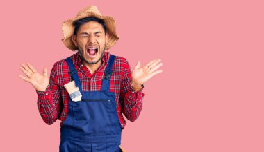 Yakışıklı Latin Amerikalı, tamirci üniforması giyen, çılgın ve başarıyı kollarını kaldırmış ve gözleri kapalı heyecanla bağırarak kutlayan genç adam. Kazanan konsept 