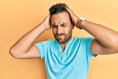 Sakallı, sıradan kıyafetler giyen, baş ağrısı çeken, çaresiz ve stresli yakışıklı bir adam. Çünkü acı ve migren. Eller başının üstünde.. 