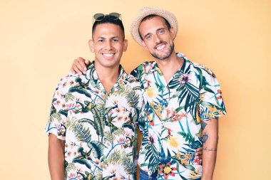 Yazlık şapkalı, Hawaii tişörtlü, mutlu ve havalı gülümseyen iki genç gay. şanslı kişi. 