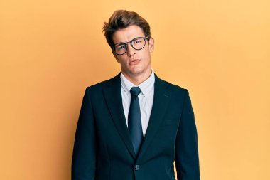 İş elbisesi ve kravat takan yakışıklı beyaz adam yüzünde ciddi bir ifadeyle rahatlamış. Basit ve doğal bir şekilde kameraya bakıyorsun.. 