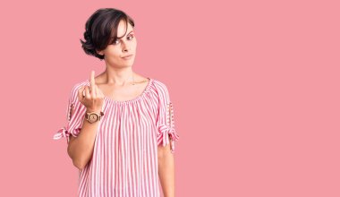 Beautiful young woman with short hair wearing casual summer clothes showing middle finger, impolite and rude fuck off expression 