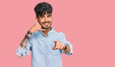 Gündelik kıyafetler giyen, gülümseyen, telefonda konuşan ve seni işaret eden İspanyol bir genç. Ara beni.. 