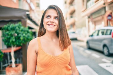 Genç ortadoğu kızı gülümseyerek şehirde mutlu mesut yürüyor..