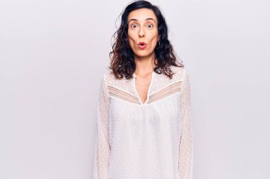 Gündelik kıyafetler giyen genç, güzel İspanyol kadın. Şaşırmak için ağzı açık kalmış, korkmuş ve şaşırmış. İnanmayan yüz. 