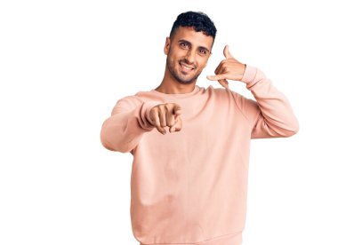 Gündelik kıyafetler giyen, gülümseyen, telefonda konuşan ve seni işaret eden İspanyol bir genç. Ara beni.. 