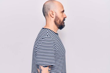 Sıradan kıyafetler giyen genç yakışıklı bir adam, rahat bir görünüm takınıyor kendine güvenen bir gülümsemeyle doğal bir yüz ifadesi takınıyor.. 