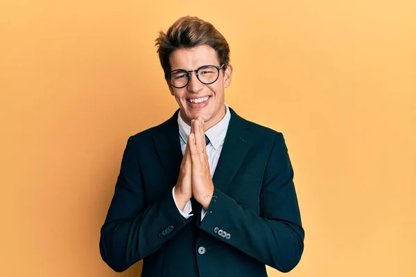 ビジネススーツを着て手で祈りを結び 自信に満ちた笑顔を許しを求めるハンサムな原因のアジア人男性 — ストック写真