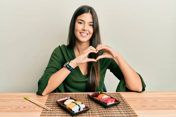 Joven Morena Comiendo Sushi Sentada Mesa Sonriendo Amor Haciendo Forma — Foto de Stock