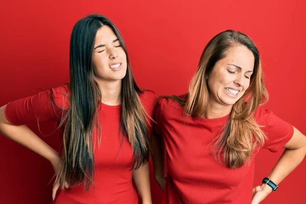 Família Hispânica Mãe Filha Vestindo Roupas Casuais Sobre Fundo Vermelho — Fotografia de Stock