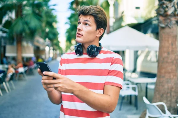 Jonge Blanke Man Met Serieuze Expressie Met Smartphone Koptelefoon Stad — Stockfoto