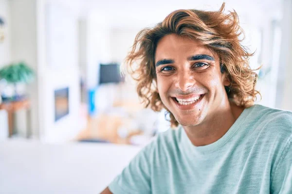 Joven Hombre Hispano Sonriendo Feliz Sentado Mesa Casa —  Fotos de Stock