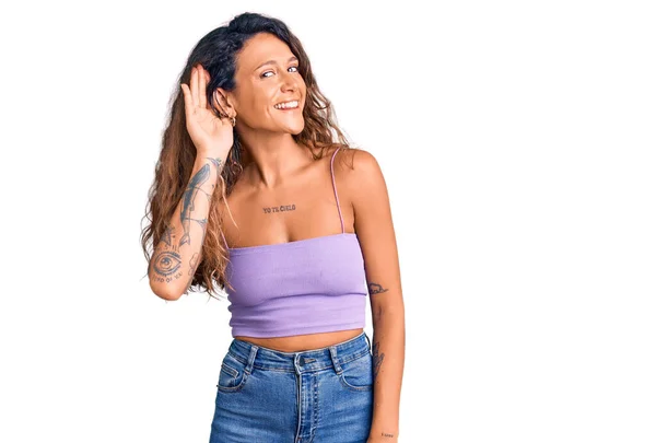 Молодая Латиноамериканка Татуировкой Повседневной Одежде Улыбающаяся Рукой Над Ухом Слушающая — стоковое фото