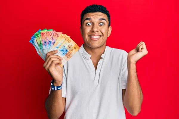 Joven Árabe Sosteniendo Billetes Banco Suizos Gritando Orgulloso Celebrando Victoria —  Fotos de Stock