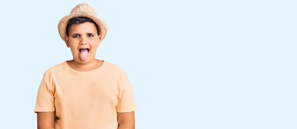 夏の帽子をかぶっている小さな男の子とハワイの水着は面白い表情で幸せ舌を突き出しています 感情の概念 — ストック写真