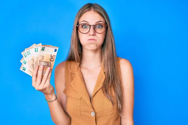 Menina Loira Jovem Segurando Notas Euro Soprando Bochechas Com Rosto — Fotografia de Stock