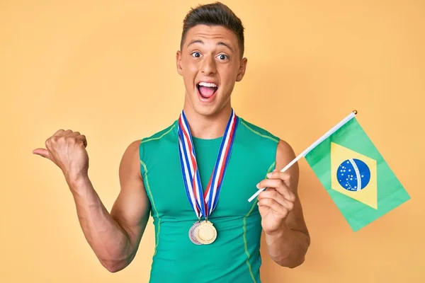 Молодой Латиноамериканец Спортивной Одежде Медалях Бразильским Флагом Указывающим Пальцем Сторону — стоковое фото
